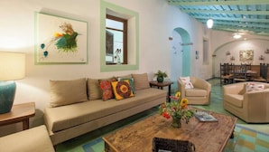 A cozy living room with a sofa, armchairs, a coffee table, and a dining area with chairs and a table.