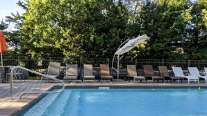 A swimming pool with lounge chairs and a metal railing. - 10 Bedroom Hampton House with a regulation size Pickleball court (Hampton Bays)