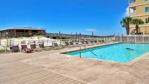Un espace piscine avec des chaises longues et une terrasse en bois.