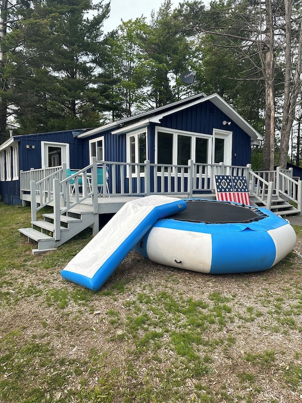 A blue house with a deck, a trampoline, and a slide. - Private cabin/beach and lake check out water sports all included (Toivola)