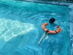 A person in a swimming pool with a lifebuoy. - Rice River Villa - Hoi An (Da Nang)