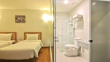 A hotel room with two beds, a shower, and a toilet.