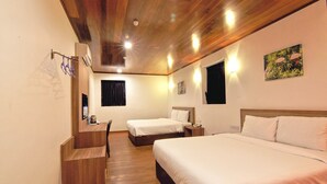 Een hotelkamer met een houten plafond, twee bedden, een bureau en een spiegel.