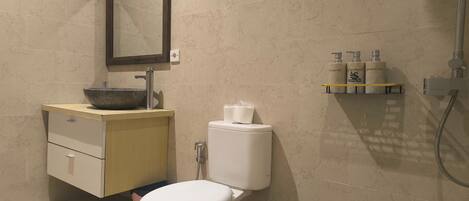 A modern bathroom with a toilet, sink, and shower.