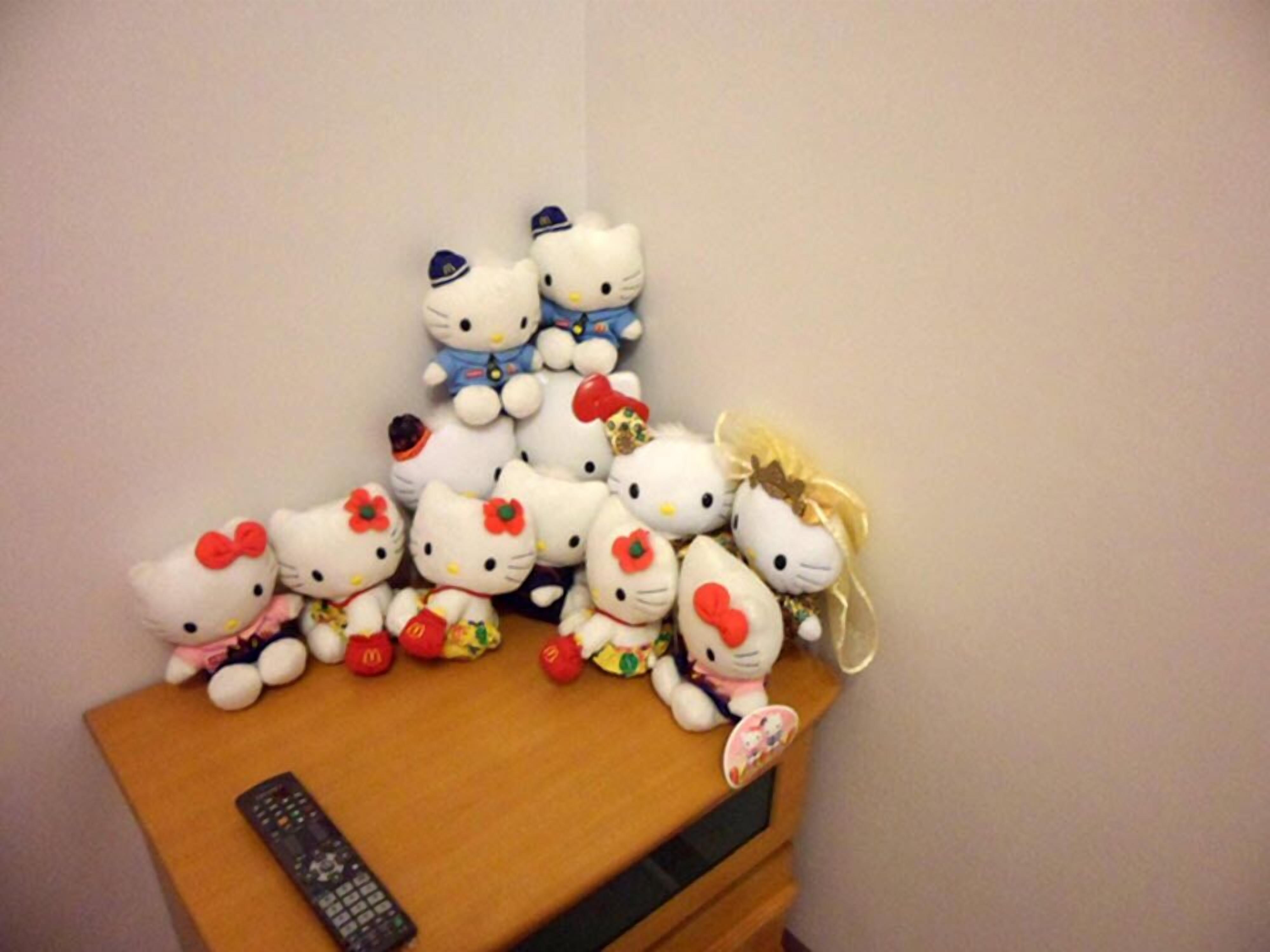 Una colección de peluches de Hello Kitty dispuesta sobre una superficie de madera.