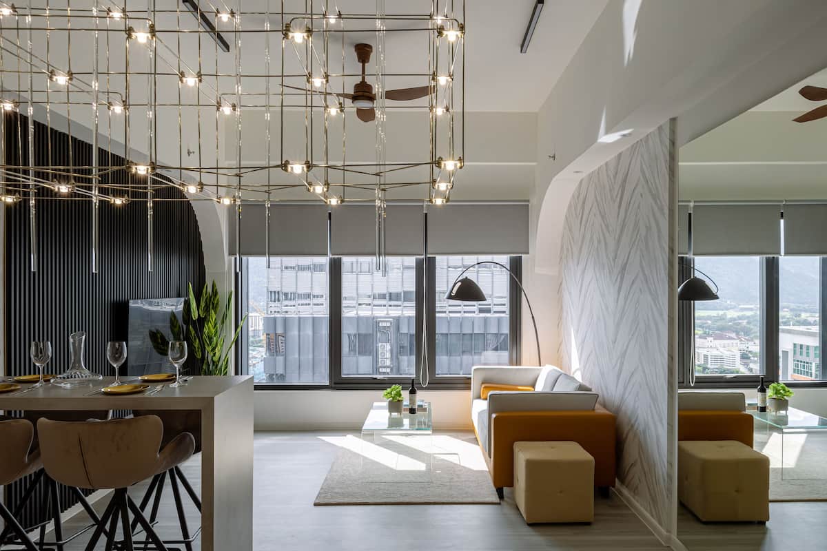 A modern living room with a sofa, ottomans, a coffee table, and a dining area with chairs and a table set for a meal.