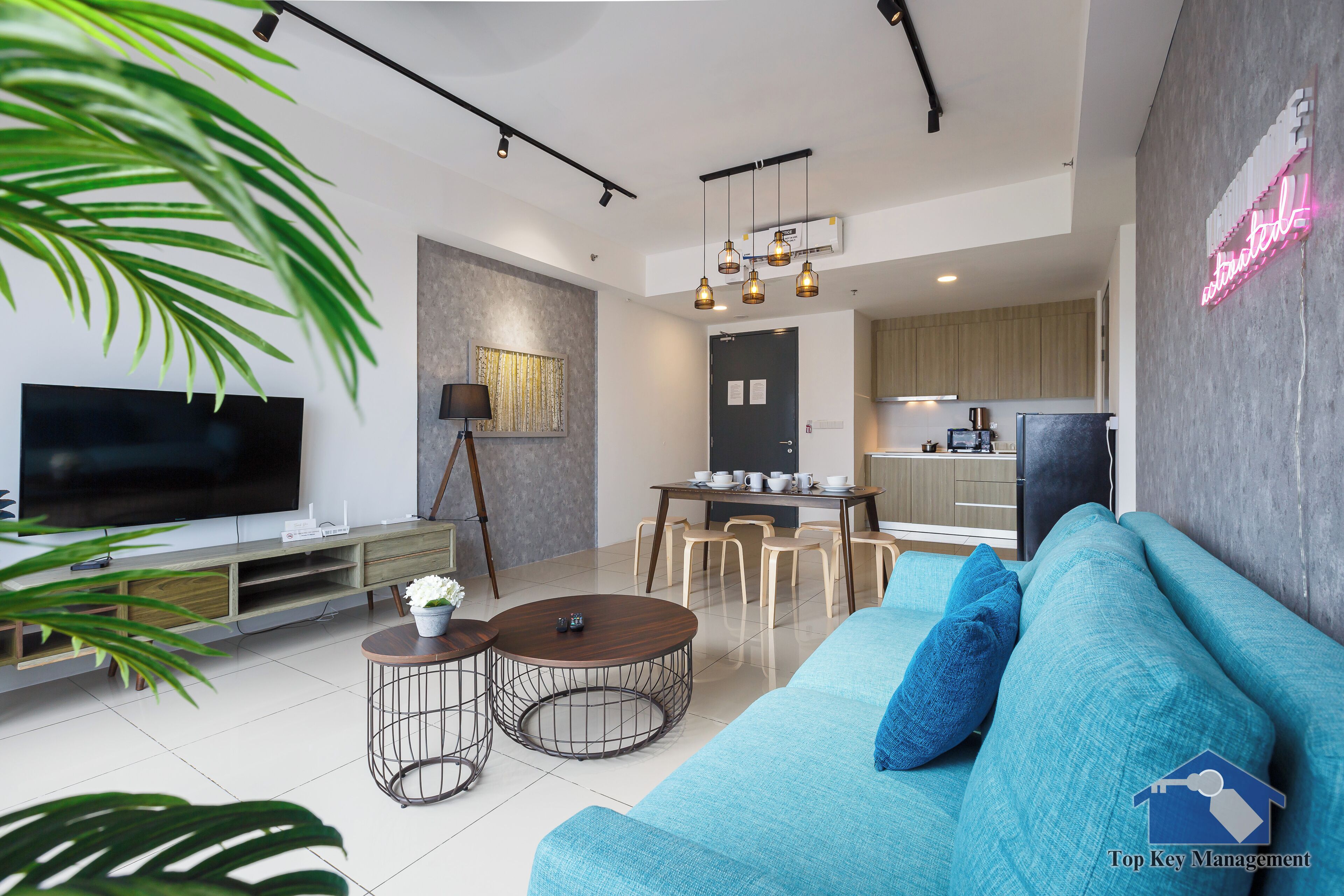A modern living room with a TV, sofa, coffee table, and dining area.