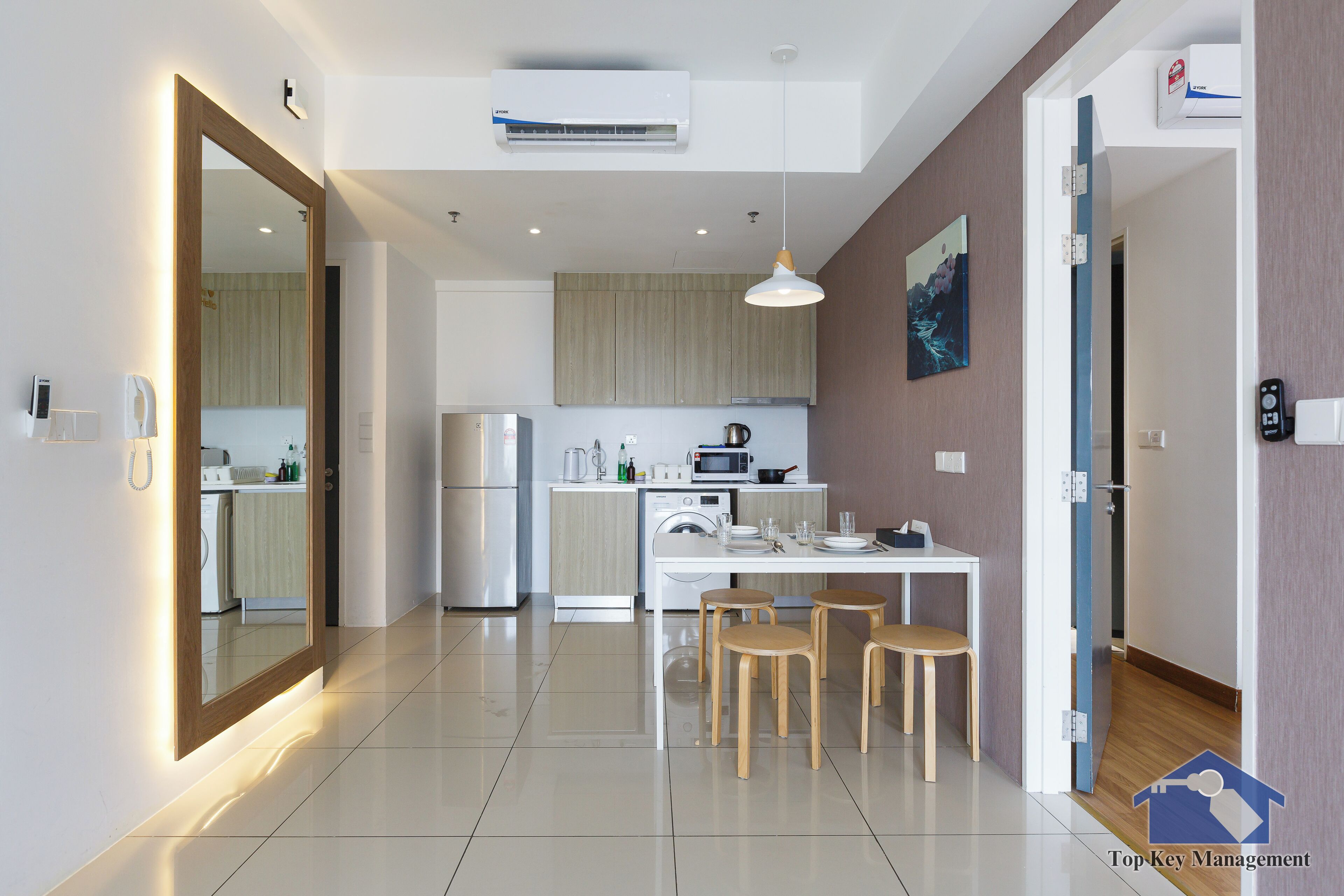 Una cucina moderna con zona pranzo, che include un tavolo bianco con sedie in legno, un forno integrato e un forno a microonde.