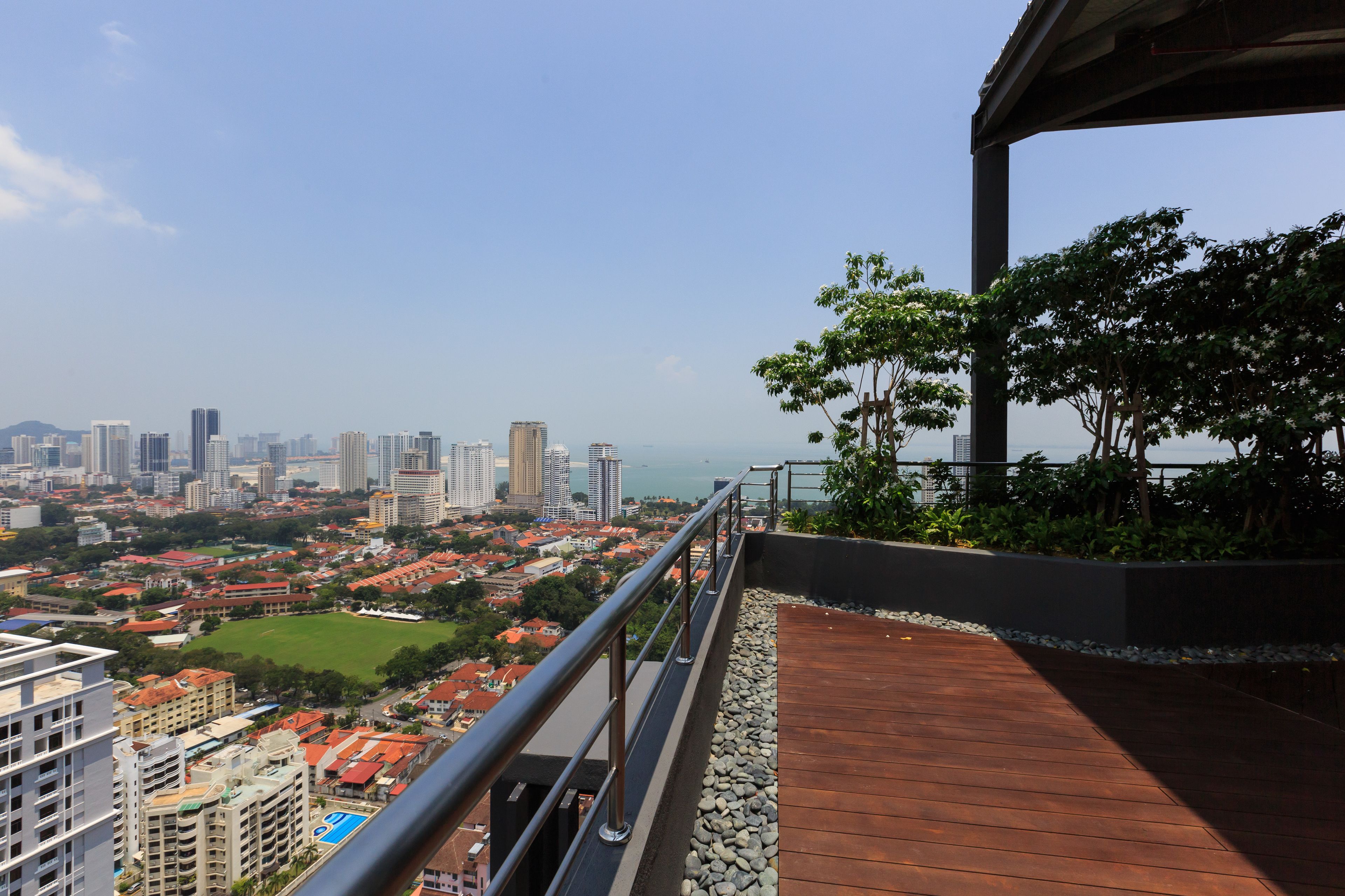 A high-rise building with a view of a cityscape, including a sports field and residential areas.