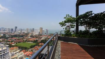 A high-rise building with a view of a cityscape, including a sports field and residential areas.