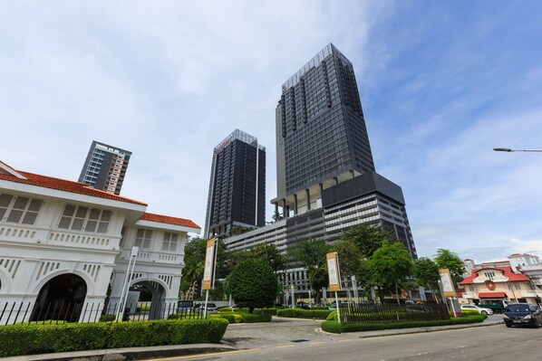 A modern urban street with high-rise buildings, a historic building with arches, and a well-maintained road. - Tropicana 218 Macalister (George Town)