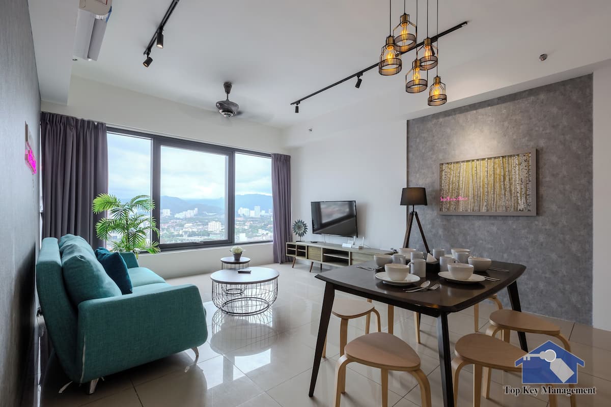 A modern living room with a sofa, dining table, and TV.
