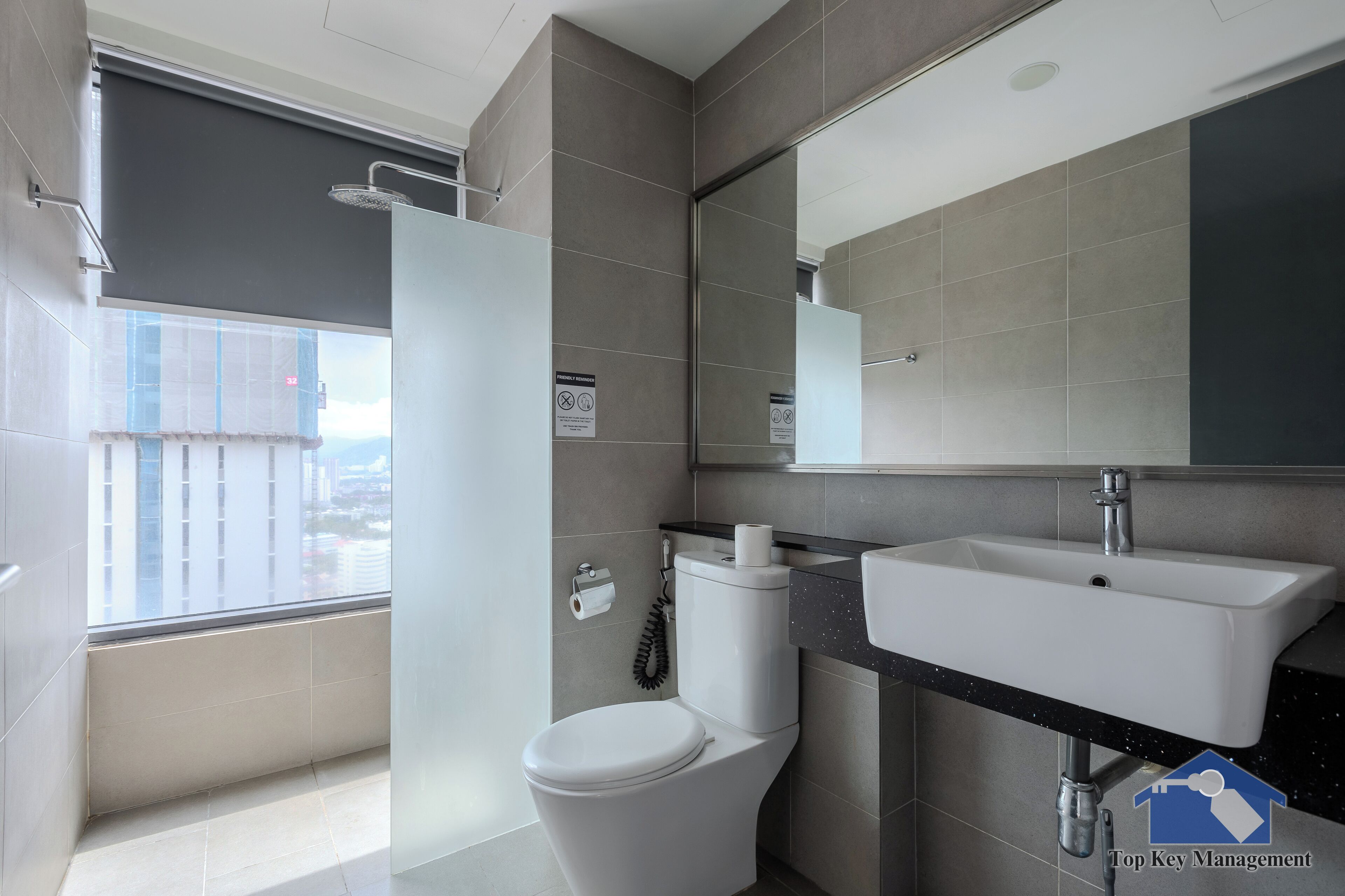 A modern bathroom with a toilet, sink, and shower.