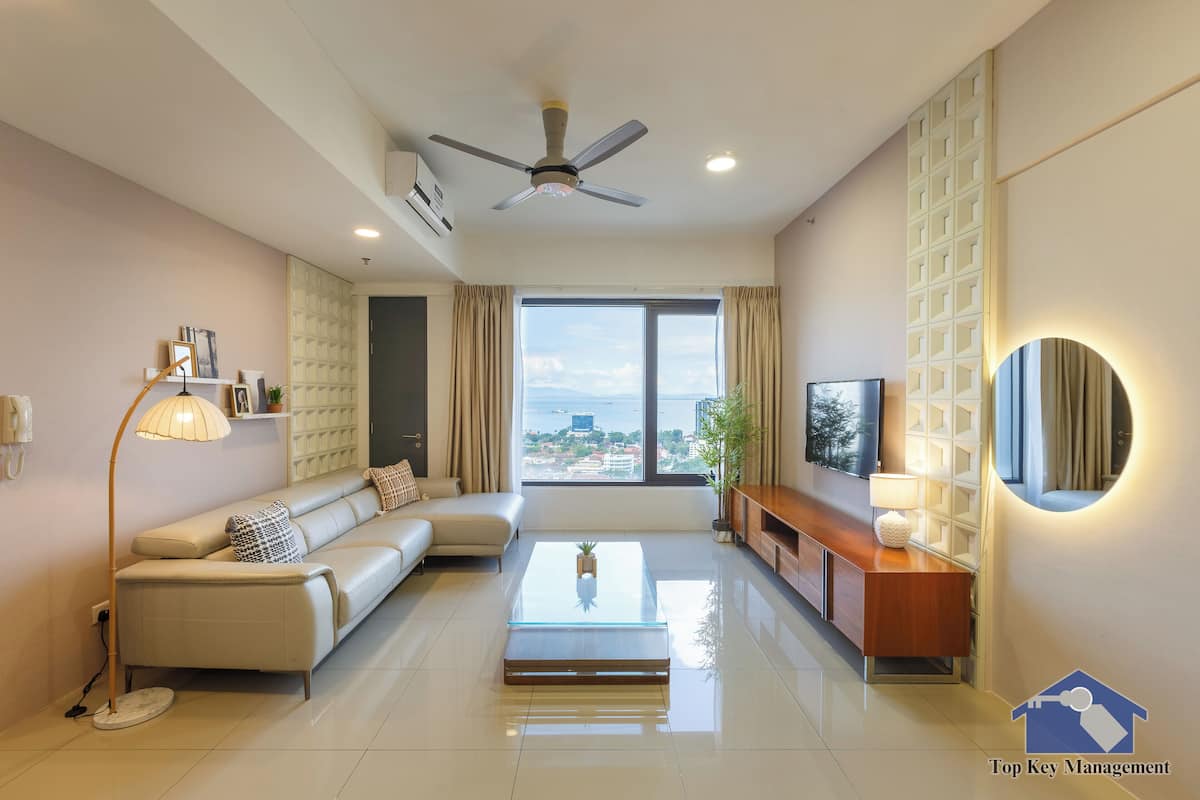 A modern living room with a sofa, a coffee table, a TV, and a ceiling fan.