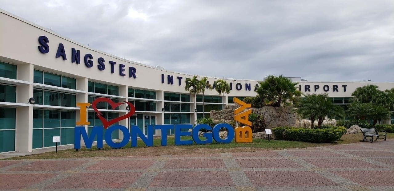 The exterior of Sangster International Airport with a large 'I ♥ MONTEGO BAY' sign.