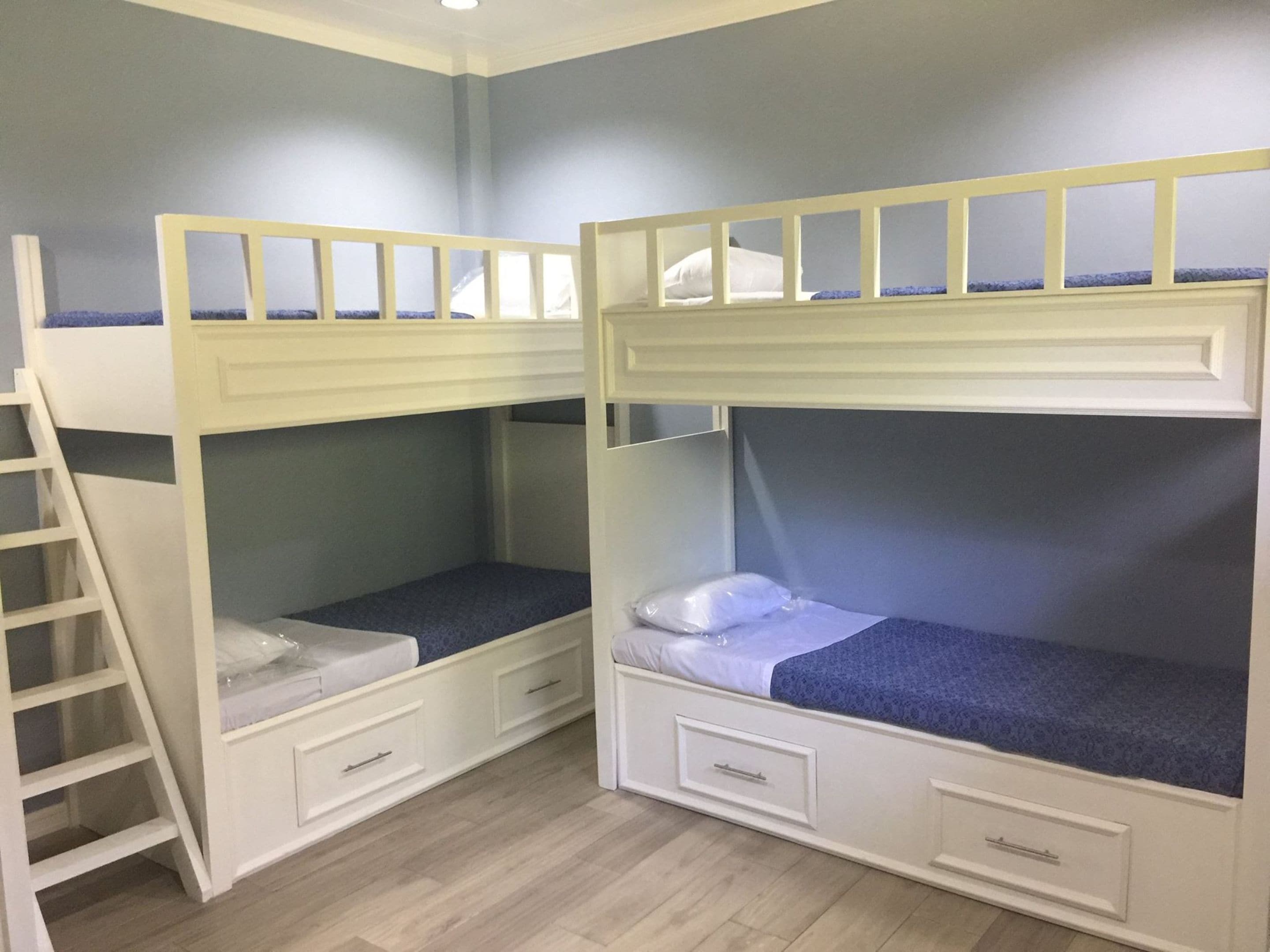 Una habitación con literas, una escalera y cajones empotrados.