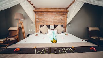 Une chambre d’hôtel avec un lit à baldaquin, un paillasson et un animal en peluche décoratif.