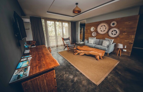 A modern living room with a wooden coffee table, a sofa, and a large rug. - Chalets Chamarel (Chamarel)