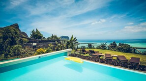 Una piscina con vista al océano y a las montañas.