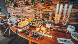 A buffet table with various food items, including fruits, cheeses, and condiments. - Chalets Chamarel (Chamarel)