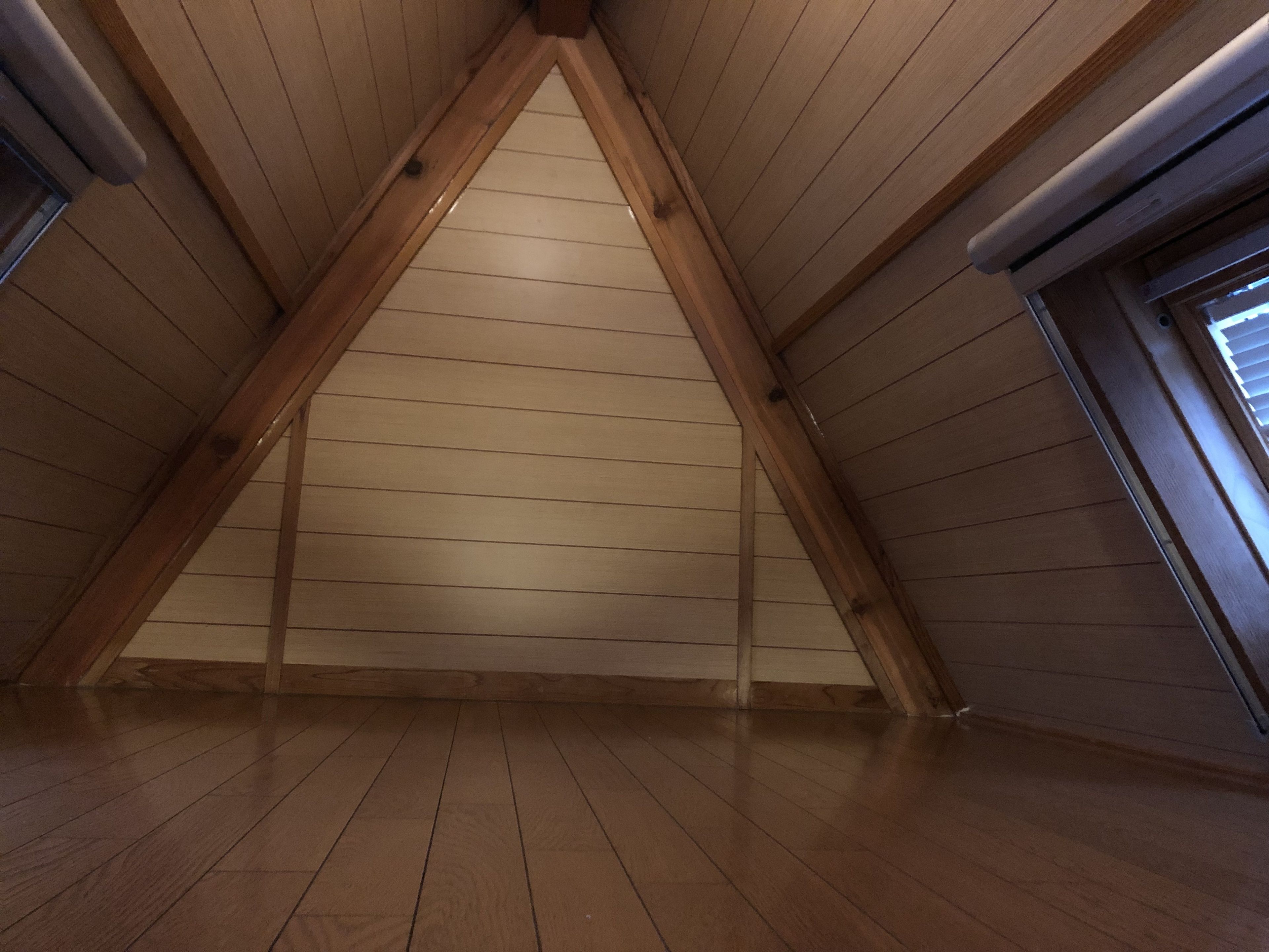 Una habitación con listones de madera en el techo y suelo de madera.