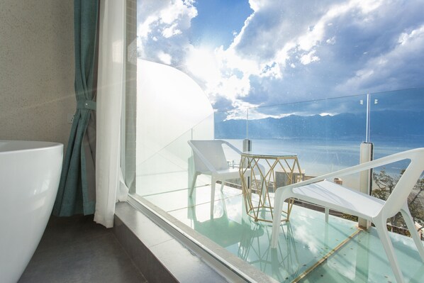 A modern bathroom with a glass-enclosed balcony overlooking a scenic view. - Butterfy Seaview Resort Villa (Dali)