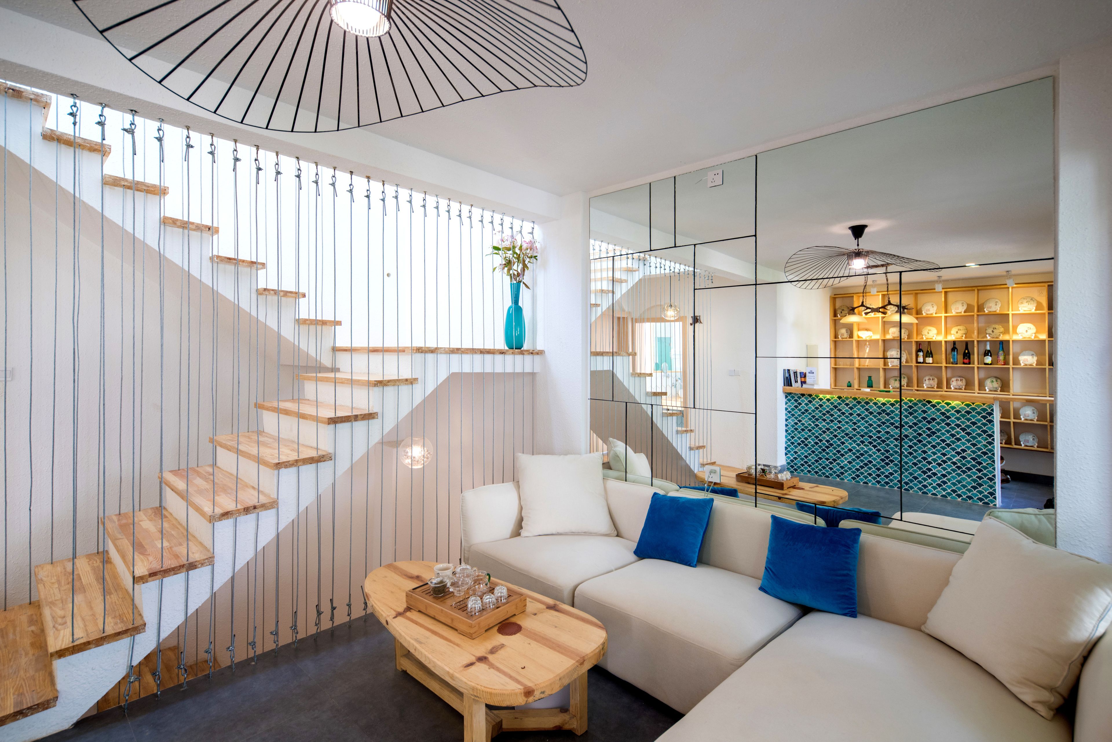 A modern living room with a staircase, a sofa, and a coffee table.
