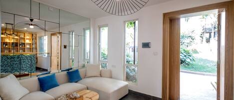 A modern living room with a sectional sofa, a wooden coffee table, and a unique ceiling light fixture.