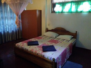 Cozy bedroom with a wooden bed, wardrobe, and window.