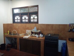 Enjoy cooking in this kitchen with a sink, stove, and kettle.