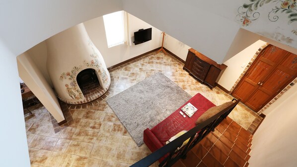 A room with a fireplace, a television, and a wooden staircase.