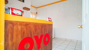 Ein Empfangsschalter mit Holzoptik, auf dem das Wort 'OYO' gut sichtbar angebracht ist.