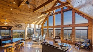 Ein geräumiges Loft mit hohen Decken, großen Fenstern für einen weiten Panoramablick, einer gemütlichen Sitzecke und einer Küche mit Bar.