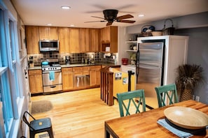 Enjoy cooking in this well-equipped kitchen with a central island, microwave, stove, oven, and refrigerator.