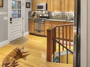 Enjoy cooking in this well-equipped kitchen with a stove, microwave, and tiled backsplash.