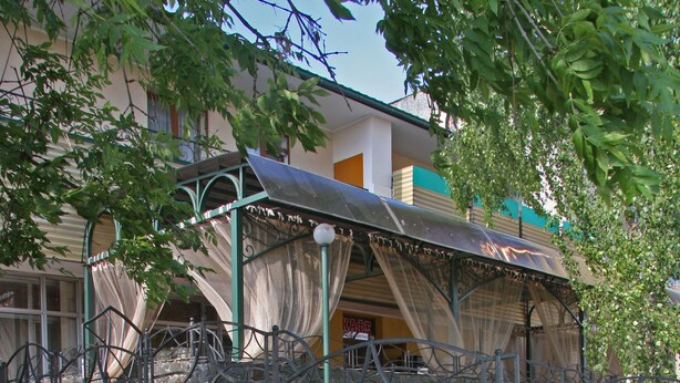 A building with a stone wall and a metal awning. - Hotel Ekran (Lviv)