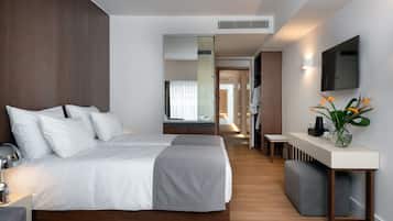 Una habitación de hotel moderna con una cama grande, mesitas de noche, un televisor y un espejo.