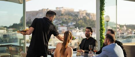 A rooftop dining area with a view of a historic cityscape.
