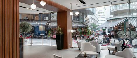 Un café moderne doté de sièges confortables, de grandes fenêtres et offrant une vue sur la rue.