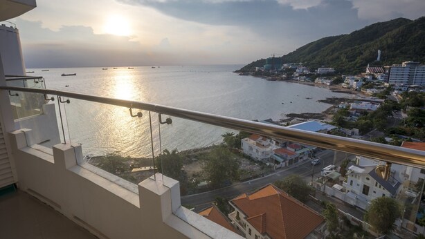 A balcony with a view of a coastal town, boats on the water, and a hill with buildings. - Cozzy and Beauty Apartment (Ho Chi Minh City)