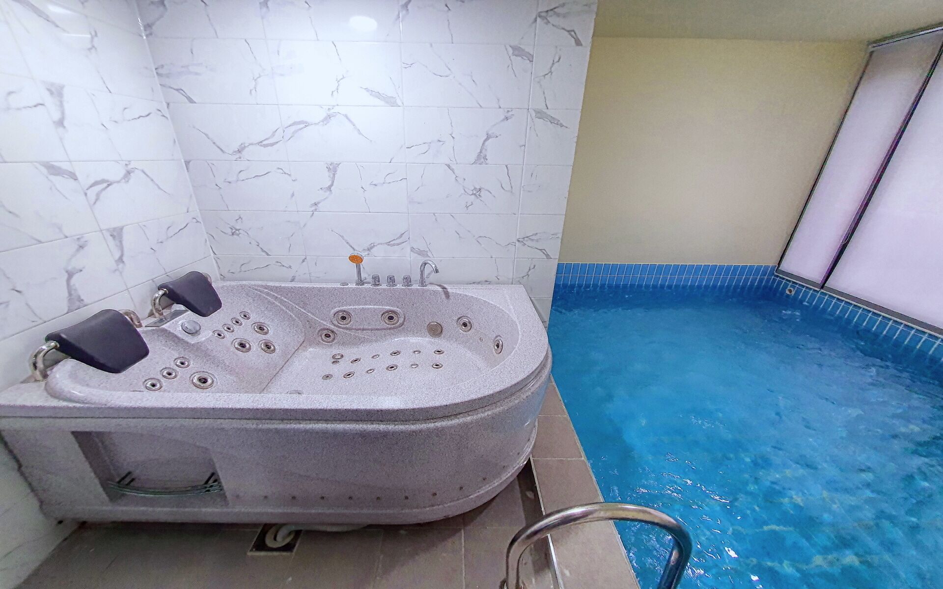 A spa area with a hot tub and a swimming pool.