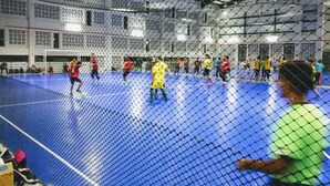 An indoor sports facility with a blue playing area, a netted enclosure, and a high ceiling with visible structural beams. - Hotel ASRC (Alor Setar)