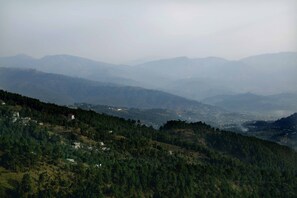 A mountainous landscape with scattered buildings. - Hotel Kausani Retreat (Somashwar)
