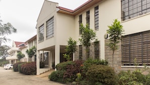 A modern residential building with a symmetrical facade, large windows, and a central entrance. - LIA Hotel & Training Centre (Nairobi)