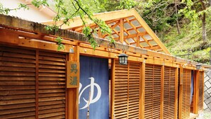 A traditional wooden structure with a shoji screen and a sign indicating a men's washroom. - Guesthouse Tomoshibi - Hostel (Matsumoto)