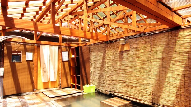 A traditional Japanese onsen with wooden beams and tatami flooring. - Guesthouse Tomoshibi - Hostel (Matsumoto)