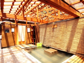 Un onsen japonés tradicional con vigas de madera y suelo de tatami.