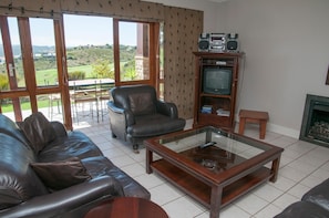 Casa adosada confort, varias camas, no fumadores, vistas al campo de golf | Zona de estar | Una televisión de pantalla plana, una chimenea