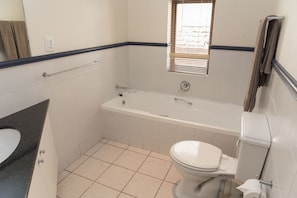 Un baño con bañera, inodoro y lavabo.
