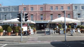A hotel with a sign reading "SEAWARD HOTEL" and outdoor seating with umbrellas.